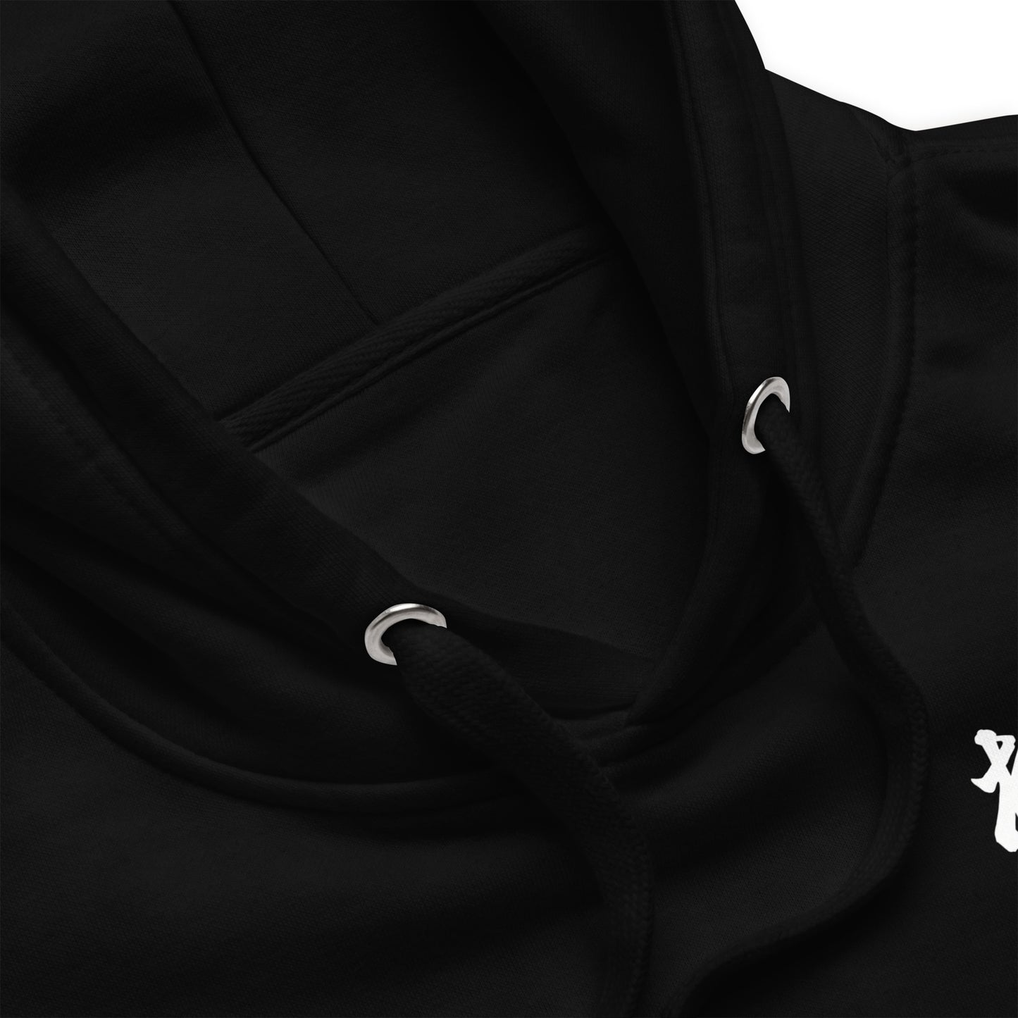 Close-up of a black hoodie showing the hood, drawstrings with silver metal eyelets, and a small white graphic on the chest.