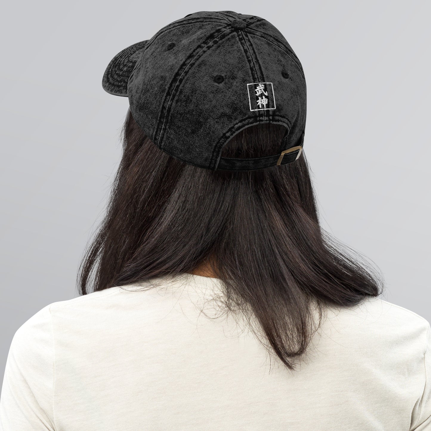 Person wearing a black cap with 'BUSHIN' logo on a gray background