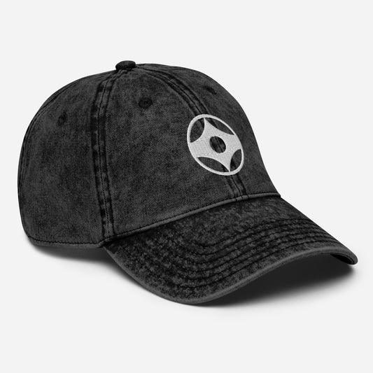 Black denim cap with white logo on a light gray background