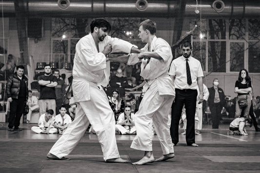 Bare-knuckle karate fighters exchanging body punches during full-contact competition
