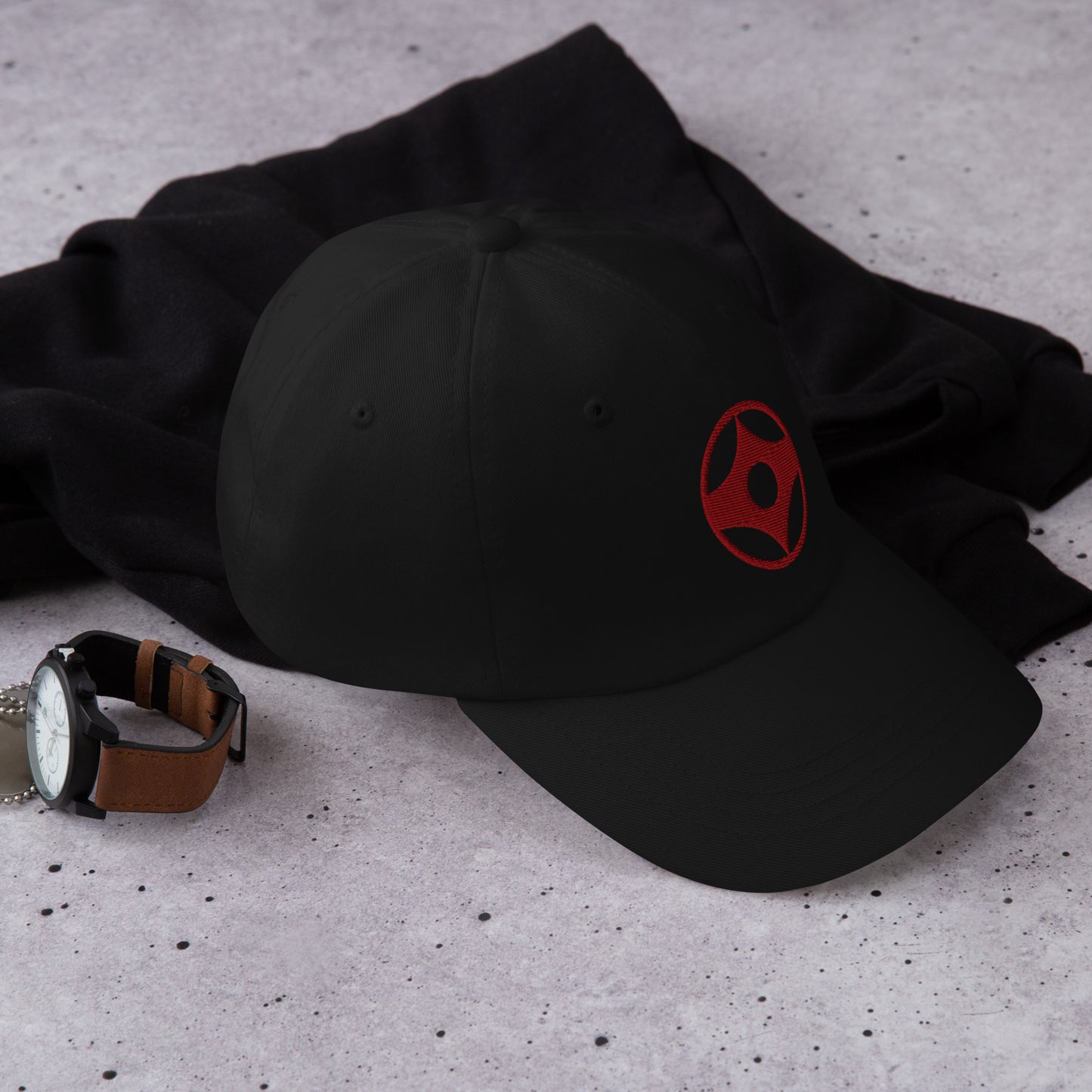Black cap and watch on a textured surface