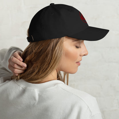 Person wearing a black cap with kanku on a neutral background