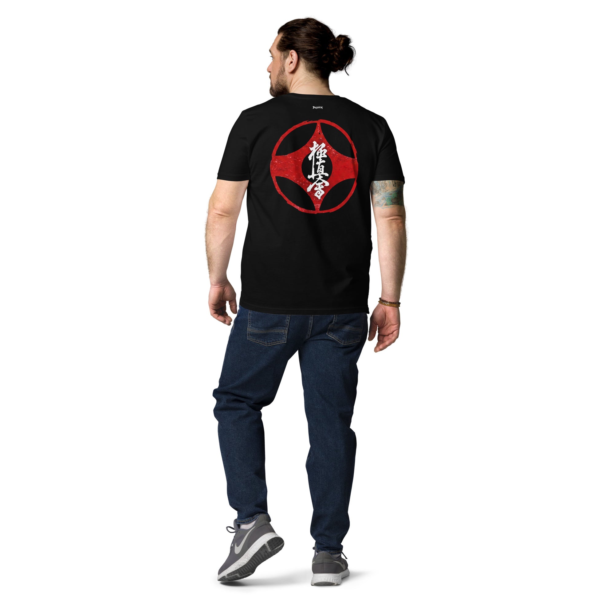 Man wearing a navy blue t-shirt with a graphic design on the back, standing against a white background.