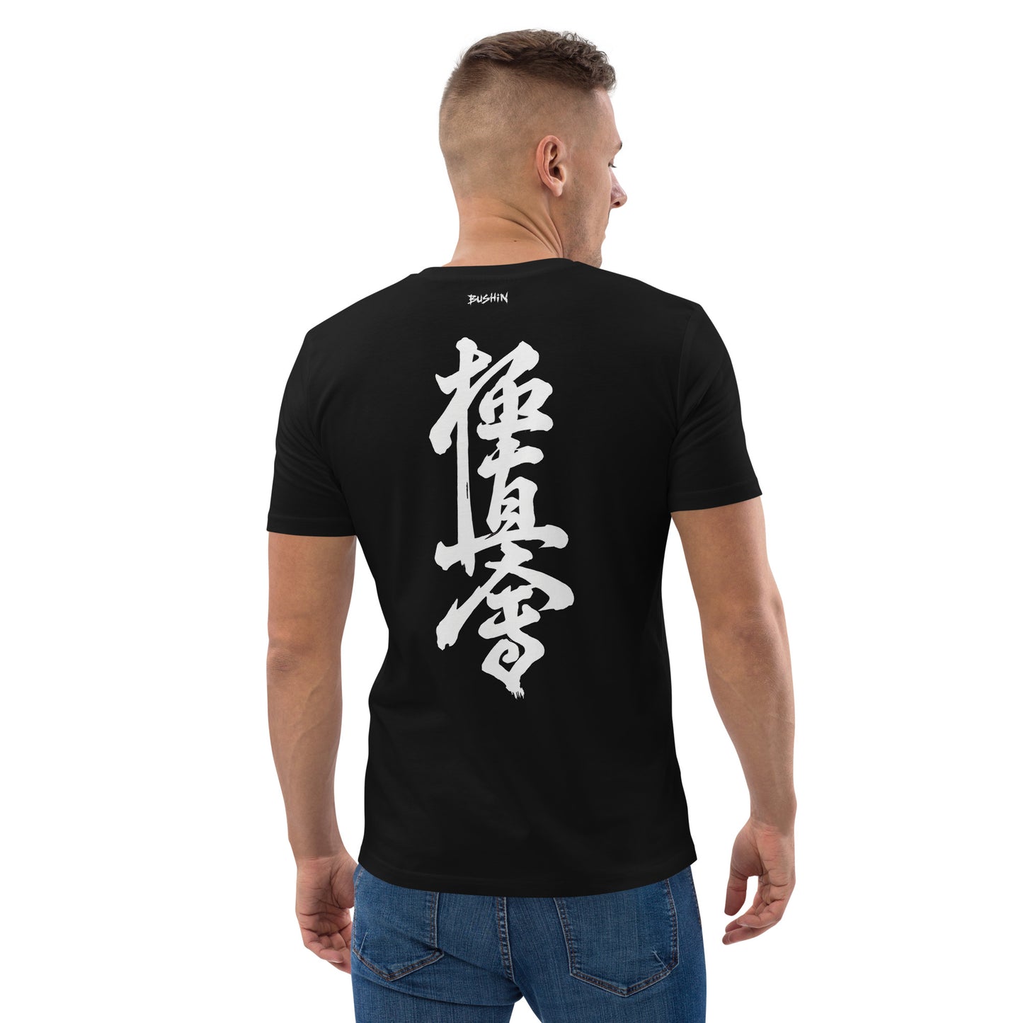 A man viewed from the back wearing a black t-shirt with large white Japanese calligraphy printed on the back, paired with blue jeans against a plain white background.