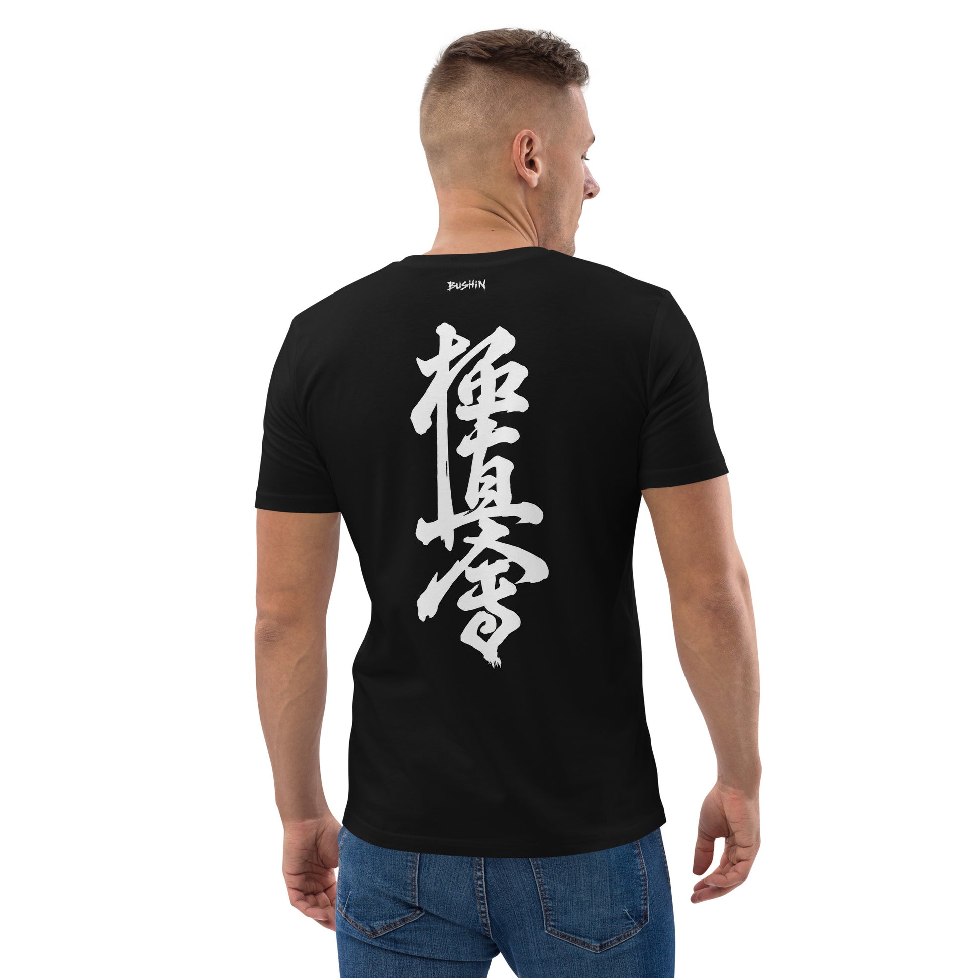 A man viewed from the back wearing a black t-shirt with large white Japanese calligraphy printed on the back, paired with blue jeans against a plain white background.