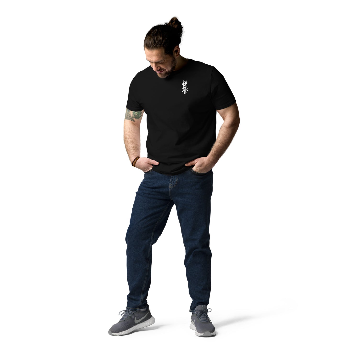 Man wearing a black t-shirt and blue jeans on a white background
