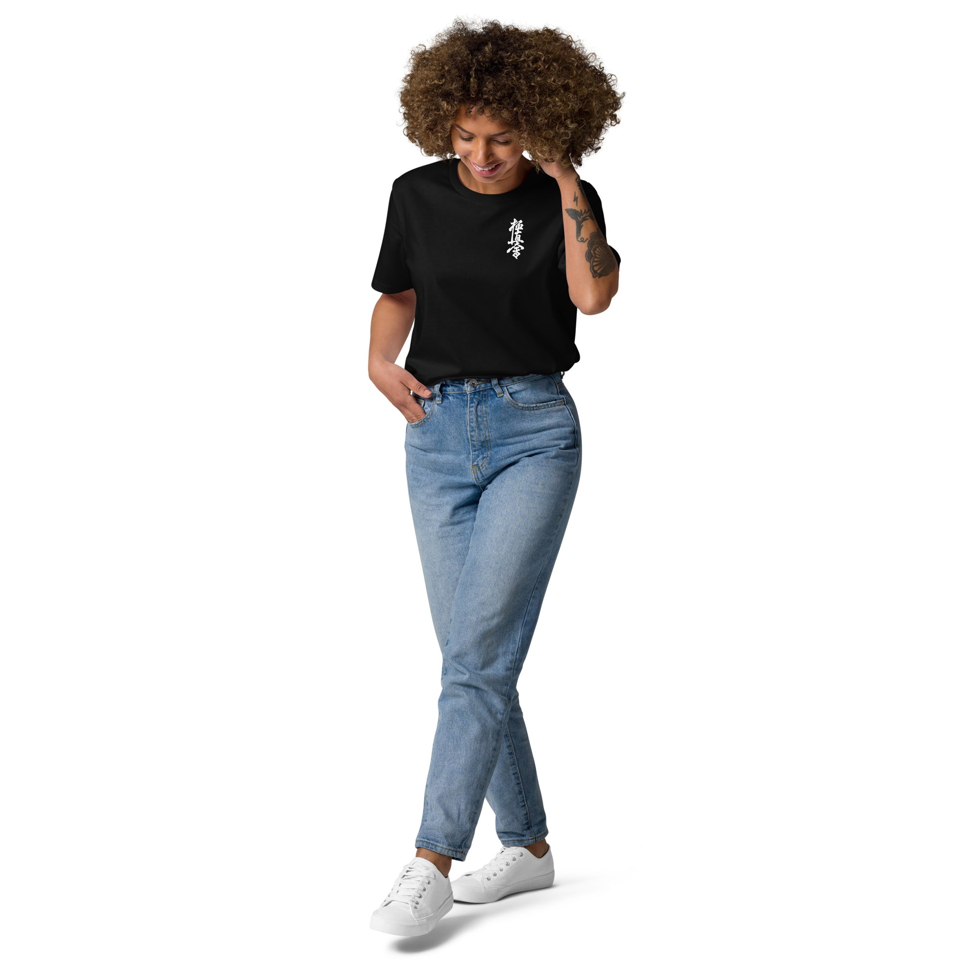 Woman wearing a black t-shirt with a red heart design and blue jeans on a white background