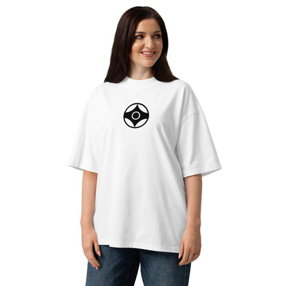 A woman wearing an oversized white t-shirt with a black circular kanku logo on the chest, paired with blue jeans, against a plain white background.