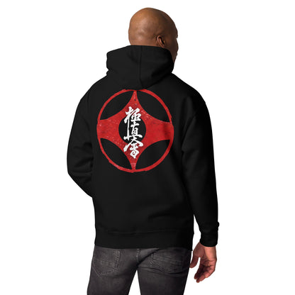 A man shown from the back wearing a black hoodie with a large red circular graphic and white Japanese characters printed on the back, paired with dark gray jeans against a plain white background.