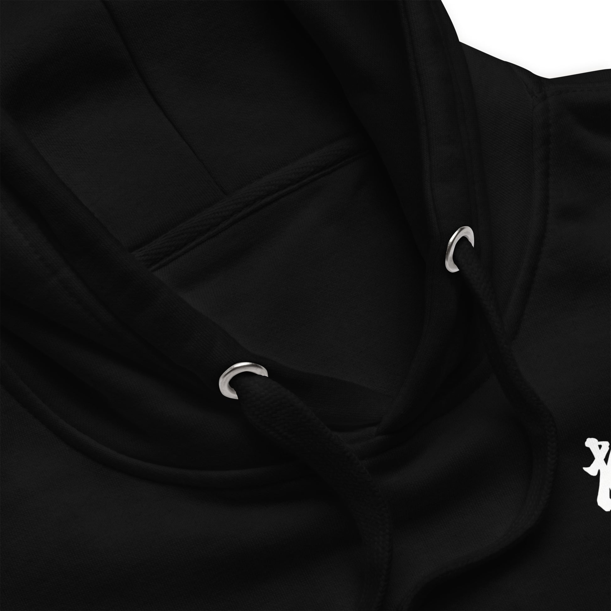 Close-up of a black hoodie showing the hood, drawstrings with silver metal eyelets, and a small white graphic on the chest.