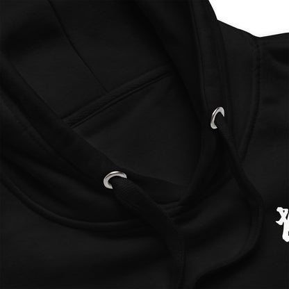 Close-up of a black hoodie showing the hood, drawstrings with silver metal eyelets, and a small white graphic on the chest.
