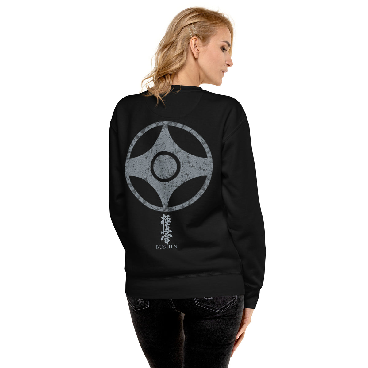 A woman shown from the back wearing a black crewneck sweatshirt with a large silver Viking raven and double axe graphic on the back, paired with black jeans against a plain white background.
