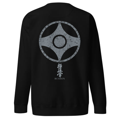 A black crewneck sweatshirt shown from the back, featuring a large distressed gray kanku graphic with Japanese kyokushin kanji and the word 'BUSHIN' printed below it.