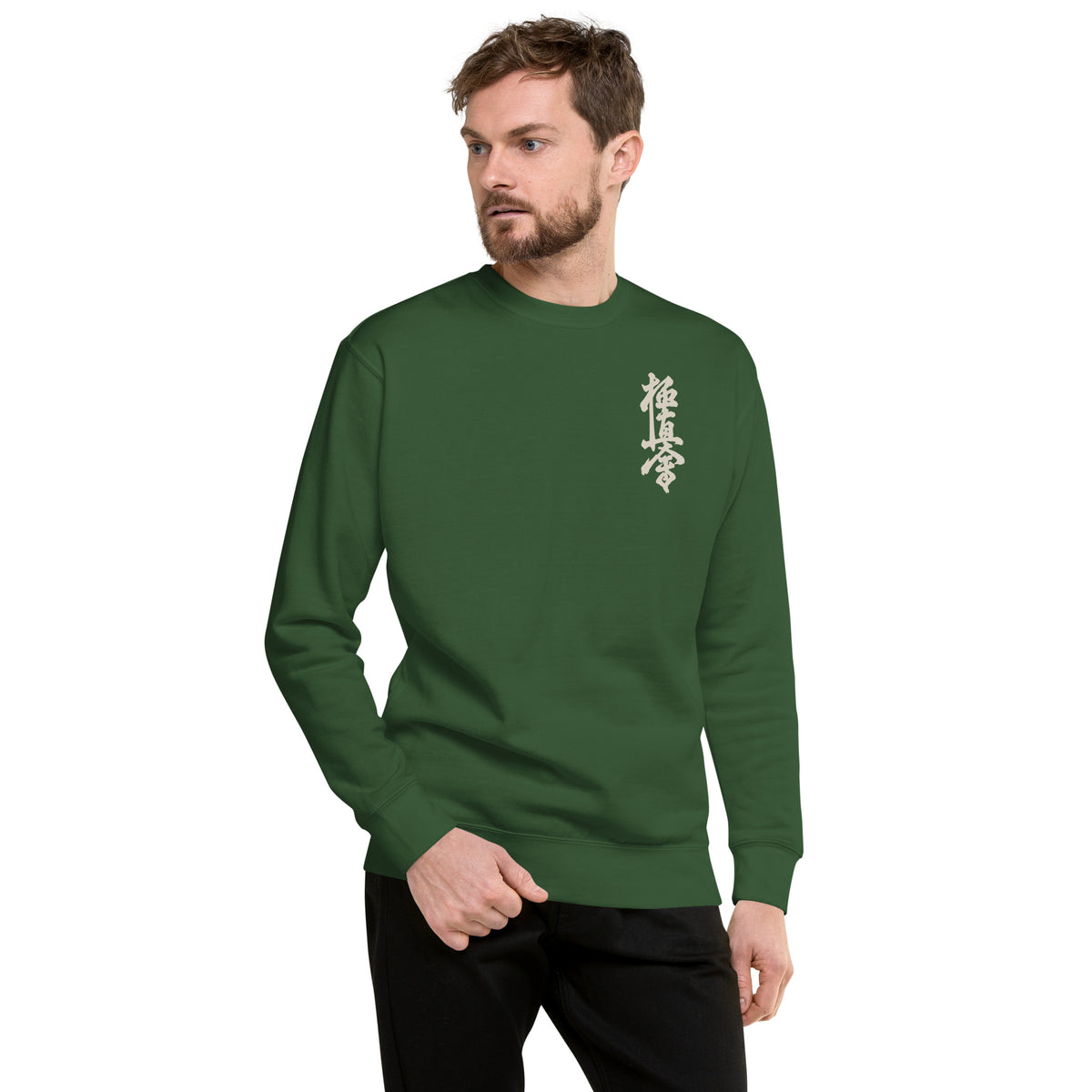 Man wearing a dark green sweater with a kyokushin logo on a green background