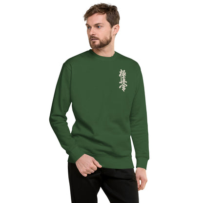 Man wearing a dark green sweater with a kyokushin logo on a green background