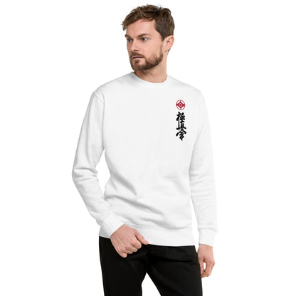 A white crewneck sweatshirt with a small red kanku logo and black kyokushin calligraphy printed vertically on the left chest, shown against a plain white background. Man wearing it