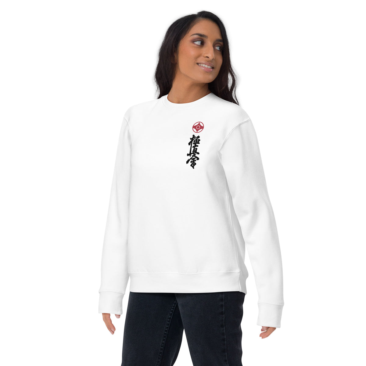 A women wearing white crewneck sweatshirt with a small red kanku logo and black kyokushin calligraphy printed vertically on the left chest, shown against a plain white background. 